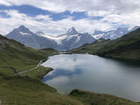 Ein Bergsee glitzert vor einer Bergkulisse in den Berner Alpen zwischen der Schynige Platte und dem First. 