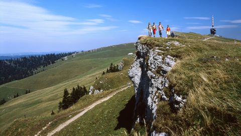 Quatre personnes se tiennent sur le Chasseral, dans le canton de Berne, et regardent au loin.
