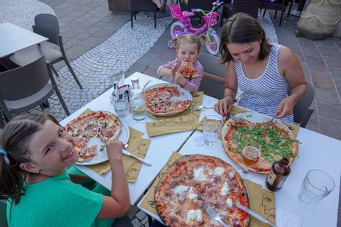 Mami mit iîhren 2 Mädels am Pizza essen. Die vierte Pizza wird wohl der Papi nach dem fotografieren essen.