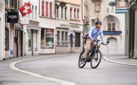 Velofahrer auf einer Strasse in der Schweiz. Rent a Bike Langzeitmiete.