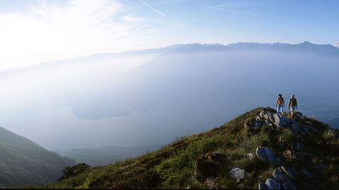 Wanderer mit einer vernebelten Aussicht auf den Luganersee. Sentiero Lago di Lugano. Wanderferien mit Eurotrek.