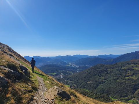 Wanderer auf einem Bergpfad mit Blick ins Tal