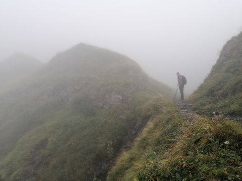 Blick auf eine Wanderin im Nebel.