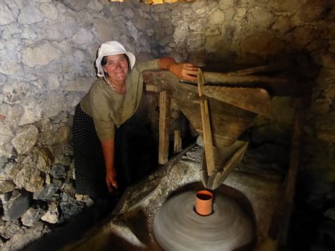 Einheimische Frau bei der Arbeit in einem Steinhaus