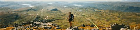 Die Aussicht vom Bitihorn aufs Tal ist unglaublich. Eine Wanderin in Norwegen betrachtet das Panorama. 