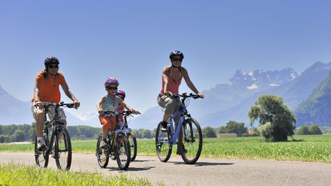 Family with mountain bikes on a path through nature
