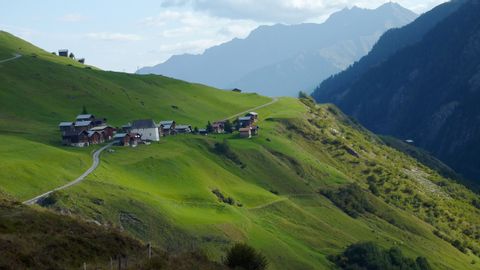 Ein winziges Dorf befindet sich in den Bergen auf dem Alpenpässe-Weg.