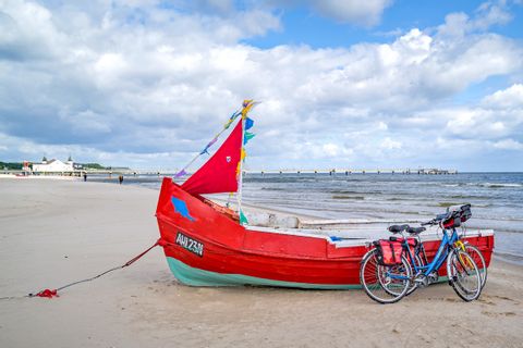 Fahrrad lehnt an einem roten Boot am Strand von Usedom