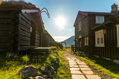 Dunkle Holzhäuser in Gjendebu in Norwegen befinden sich am Wegrand. 
