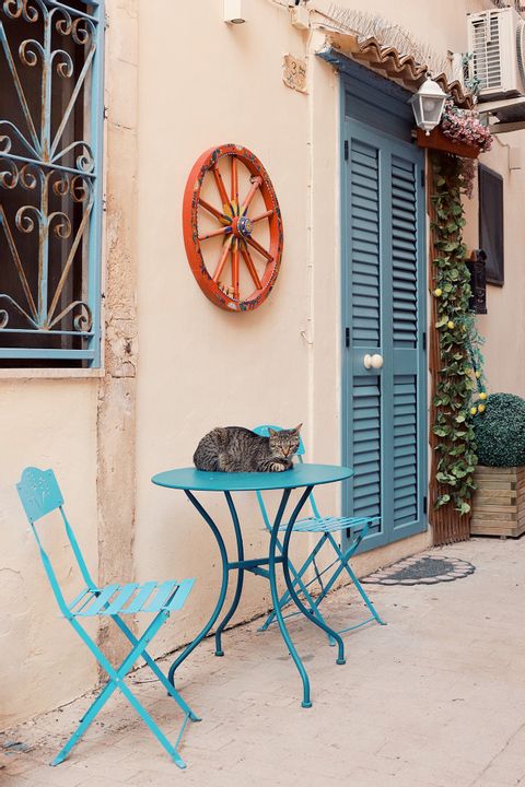 Eine Katze liegt gemütlich auf einem Tisch in den Gassen von Syrakus.