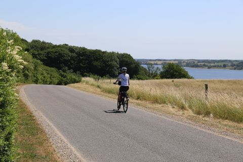 Ines fait du vélo sur une route au Danemark.