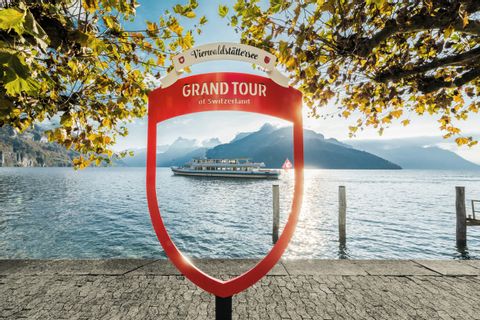 Ein Fotopunkt von Grand Tour Switzerland am Vierwaldstättersee in Brunnen. Im Hintergrund ein Schiff. 