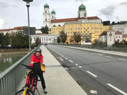 Prisca à vélo sur le pont, devant la cathédrale Saint-Étienne de Passau.