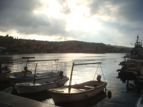 Schiffe an einem Steg. Die Sonne scheint leicht durch die Wolken hindurch. Rad-Schiff Dalmatien mit Eurotrek. 