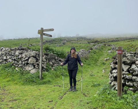 Riana steht nebene einer Steinmauer auf El Hierro, welche an die Hadrians Wall in Schottland erinnert. 