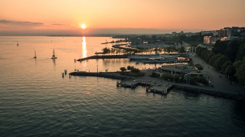 Le soleil se couche sur le lac Léman et on voit le port de Lausanne. 