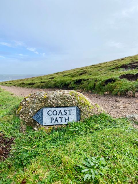 Felsen mit Markierung für den Coast Path.