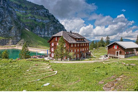 Ein typisches schweizer Berggasthaus steht an einem Bergsee