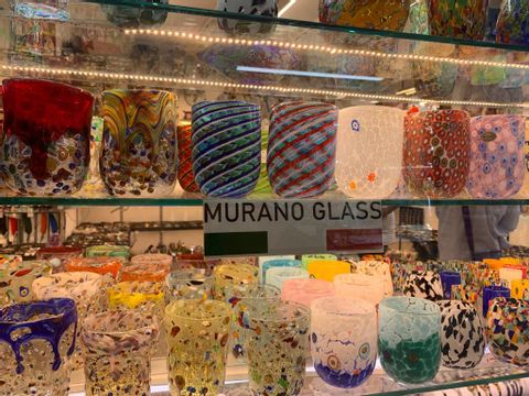 Im Regal eines Ladens stehen bunte Gläser von Murano. 