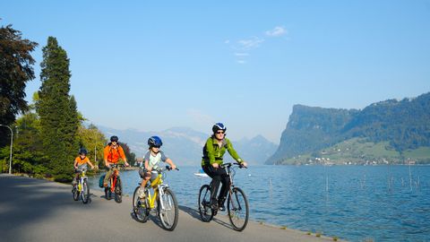 A family cycling along the shores of Lake Lucerne.
