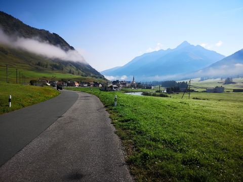 Eine Strasse führt in ein kleines Dorf im Schweizerischen Nationalpark.