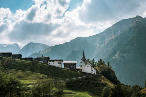 Häuser und Kirche an einem Berghang mit Ausblick