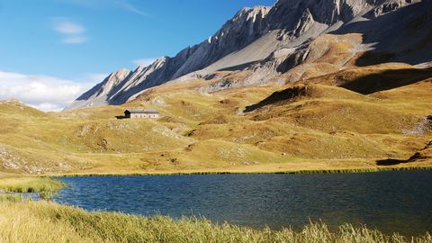 A mountain lake slumbers in the untouched nature above the tree line on Eurotrek's Graubünden East bike tour between Scuol and Teifencastel.