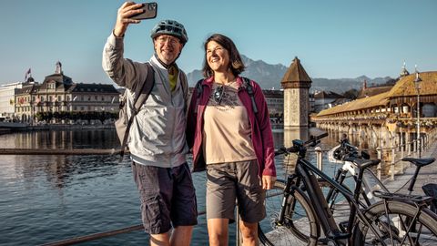 Un couple fait une pause pour un selfie devant le pont de la Chapelle à Lucerne.