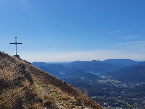 Kreuz auf einem Berggipfel mit Blick ins Tal