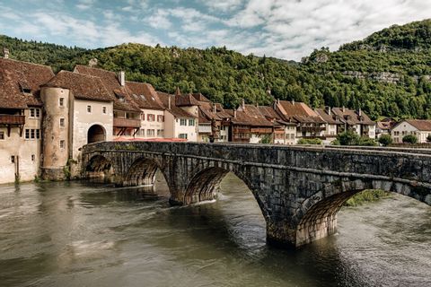 Die Steinbrücke vor St-Ursanne, Doubs Bridge mit Fluss darunter. 