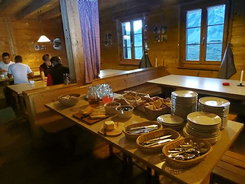 Dans une hutte, les assiettes et les couverts sont prêts pour le repas.