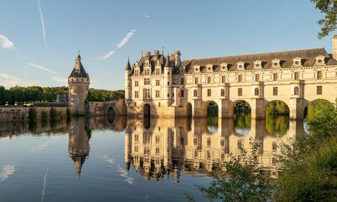 Über die Loire sieht man auf das Wasserschloss Chenonceau im Loiretal, dass sich im Wasser spiegelt.