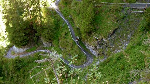 Steep mountain path on which a mountain biker descends.