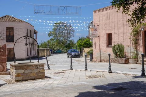 Ein Brunnen steht auf einem kleinen Platz inmitten eines kleinen Dorfes auf Sardinien.