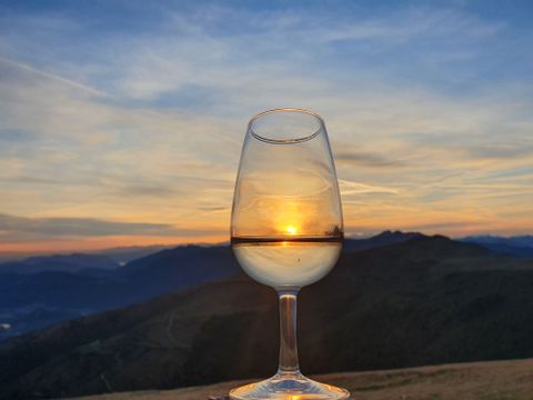 Ein Weissweinglas vor dem Sonnenuntergang.