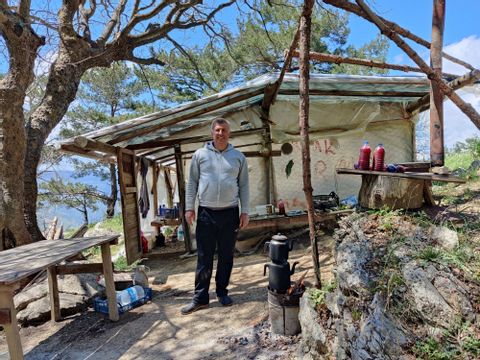 Türkischer Mann steht vor Zelt und macht Granatapfelsaft davor 