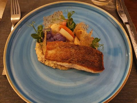 Ein Fisch zubereitet auf einem blauen Teller in der Osteria Antica in Locarno. 