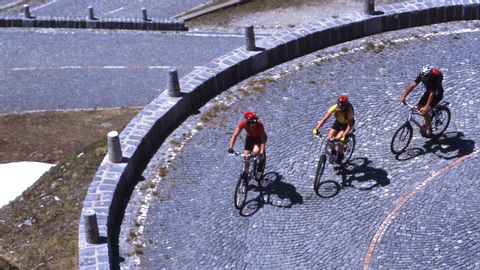 Cycliste sur une route de pierre. Vélo Gottardo. Vacances à vélo avec Eurotrek.