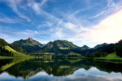 Der Schwarzsee mit bewachsten Bergen im Hintergrund.