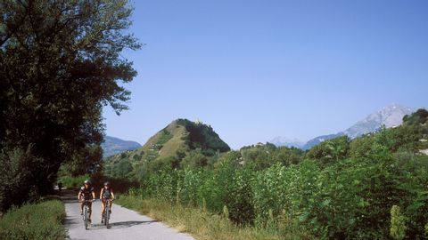 Zwei Mountainbikefahrer gemütlich auf einer Nebenstrasse am fahren. 