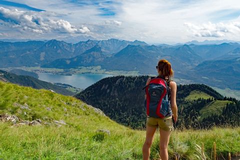 Hiker with view to lake Wolfgangsee and the alpine peaks of Salzkammergut