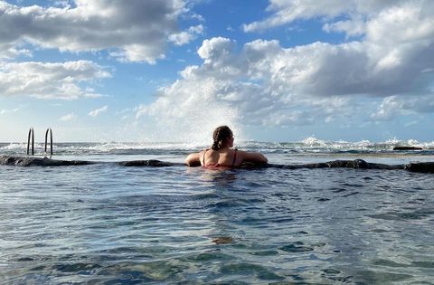 Riana badet in den Naturpools von El Hierro und blickt auf die Küste. 