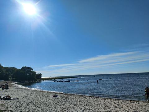 Ein Sandstrand in Visby mit direkter Sonneneinstrahlung von links. 
