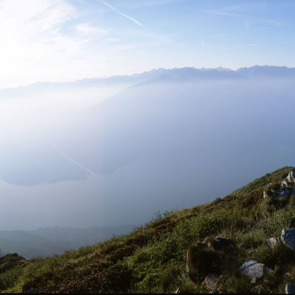 Wanderer mit einer vernebelten Aussicht auf den Luganersee. Sentiero Lago di Lugano. Wanderferien mit Eurotrek.
