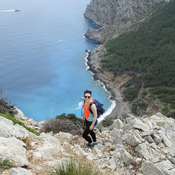 Image d'une randonneuse sur une falaise. On voit la mer en arrière-plan. Randonnée sur une finca de Majorque. Vacances de randonnée avec Eurotrek.