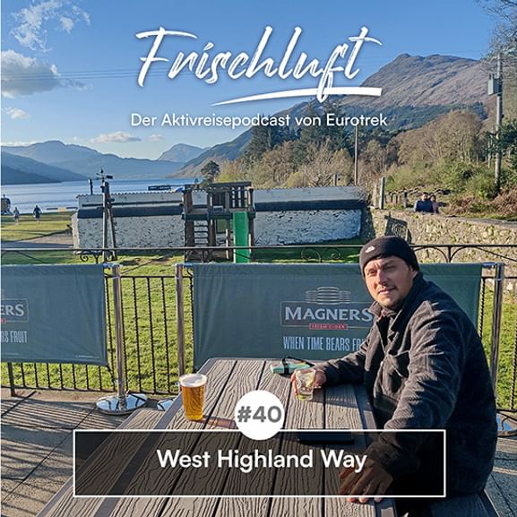 Mann auf Seeterrasse mit Bier, Berge im Hintergrund. Texteinblendung: Frischluft Podcast Folge 40, West Highland Way.