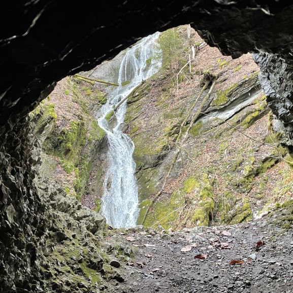 Blick auf einen Thur-Wasserfall durch ein Steinloch fotografiert