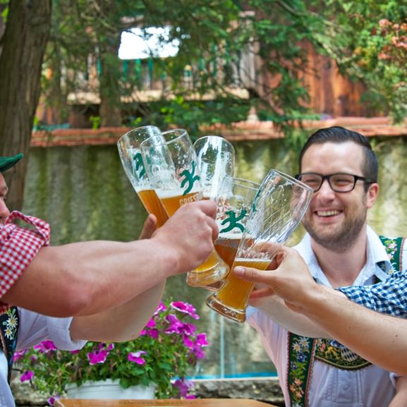 Fünf Männer in Tracht stoßen mit Bier an