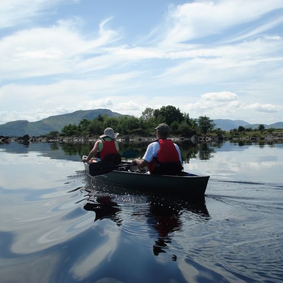 Zwei Kanufahrer fahren in Schweden auf einem See.