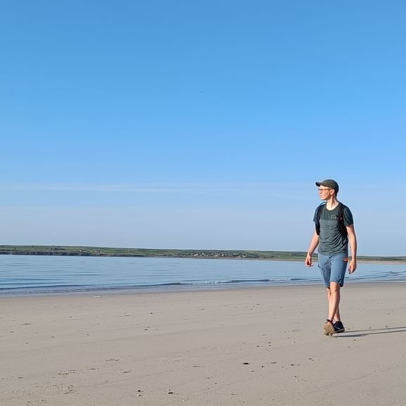 Günther se promène le long de la plage lors de son voyage de randonnée en Irlande.
